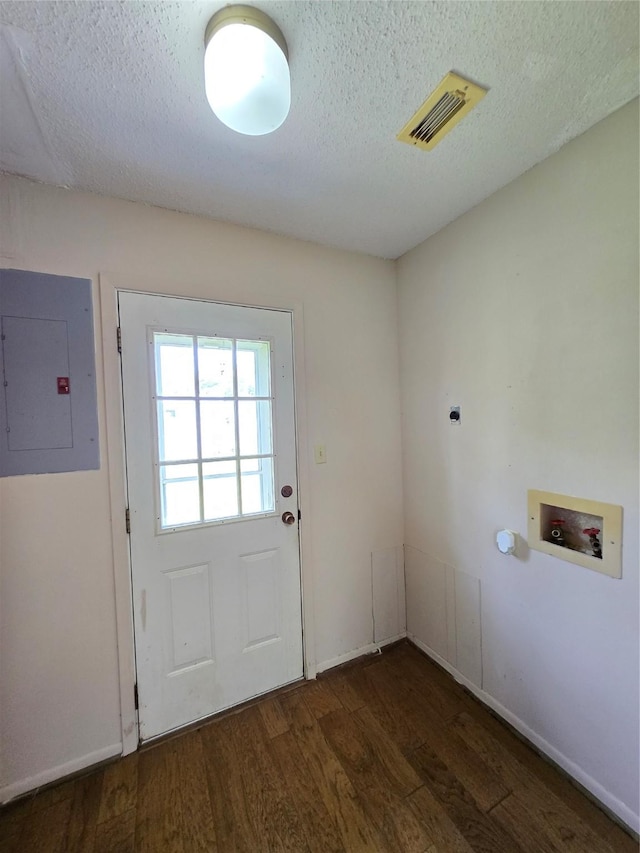 1495 W Bayshore Dr, Palacios, TX 77465 - laundry room featuring electric panel, hookup for a washing machine, a textured ceiling, wood finished floors, and baseboards
