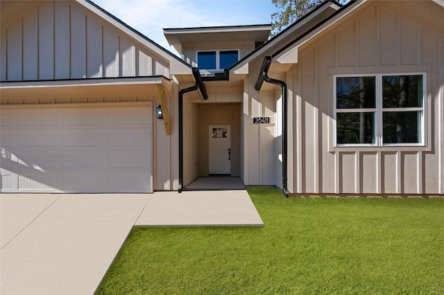 entrance to property featuring a yard and a garage