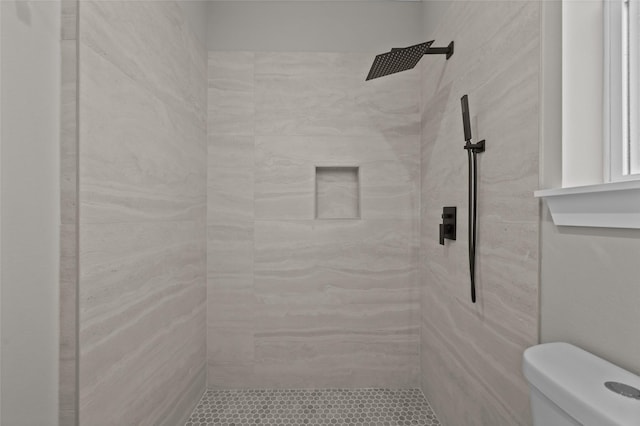 bathroom with toilet and a tile shower