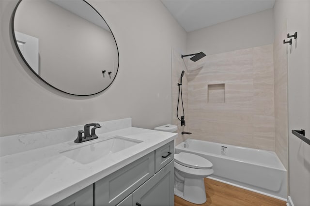 full bathroom with toilet, vanity, tiled shower / bath combo, and hardwood / wood-style flooring