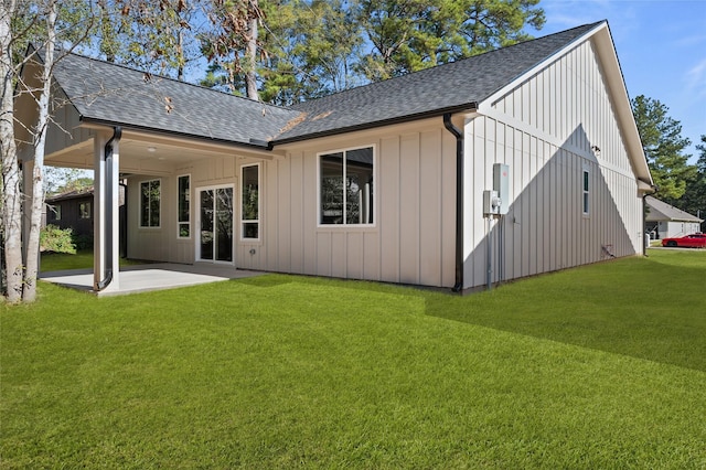 rear view of property featuring a lawn and a patio