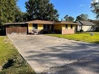 ranch-style home with a front lawn and a carport