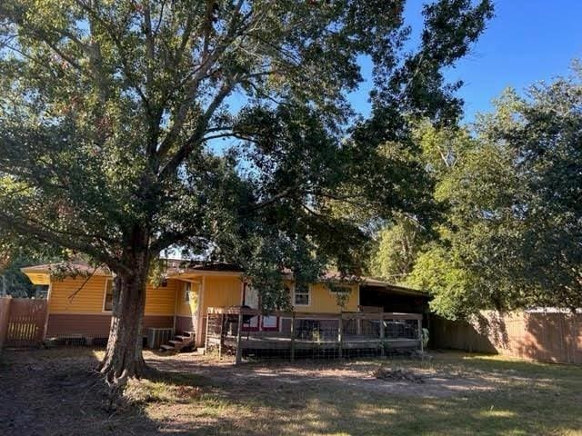 rear view of house featuring a carport and a deck