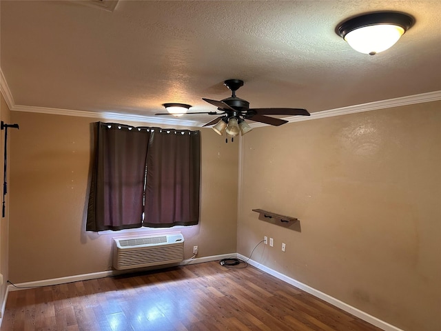 unfurnished room with a wall mounted air conditioner, dark hardwood / wood-style flooring, ornamental molding, a textured ceiling, and ceiling fan