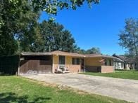 ranch-style home with a carport and a front lawn