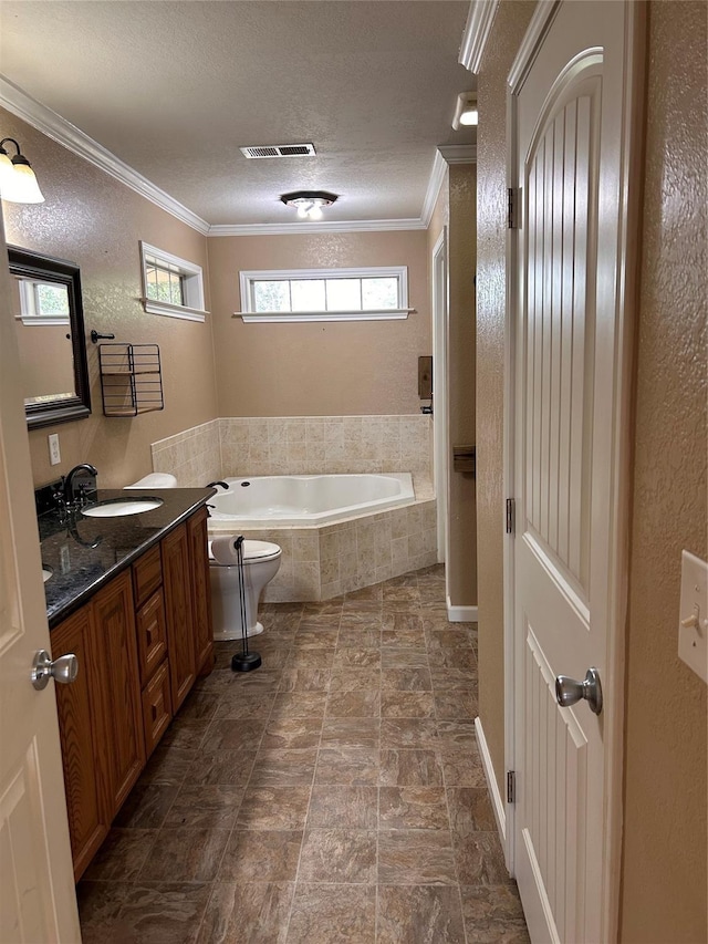 bathroom with a textured ceiling, vanity, a relaxing tiled tub, and crown molding