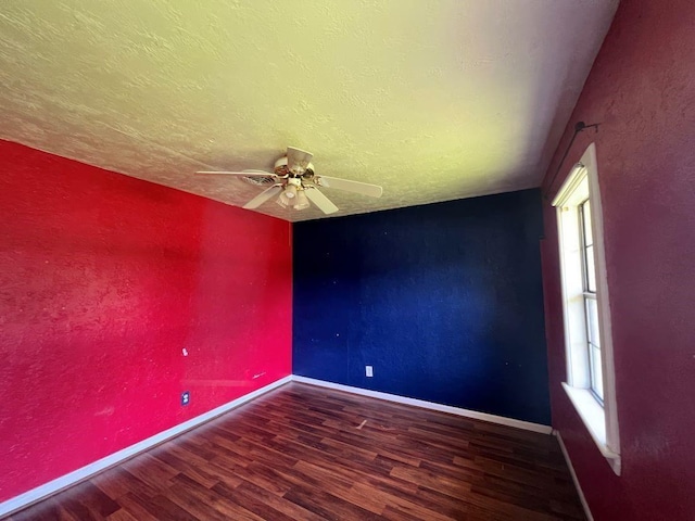 empty room featuring a textured ceiling, dark hardwood / wood-style flooring, and ceiling fan