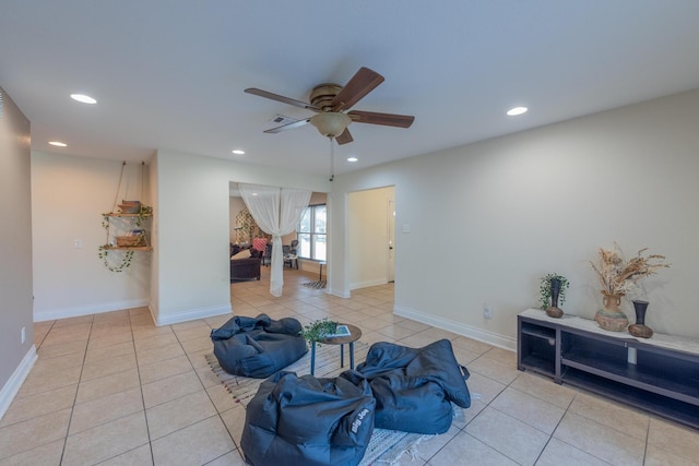 living area with ceiling fan and light tile patterned floors