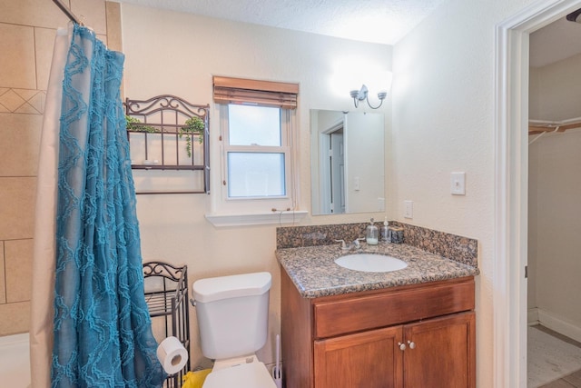 bathroom with vanity, curtained shower, toilet, and a textured ceiling