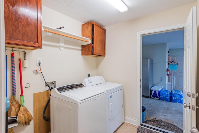 laundry room featuring cabinets and washer and dryer