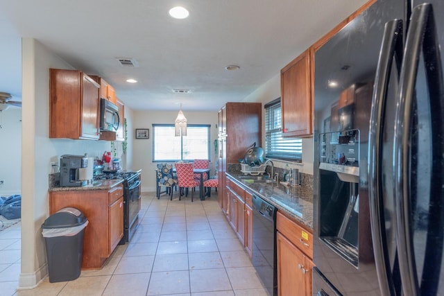 kitchen featuring hanging light fixtures, light tile patterned floors, black appliances, and sink