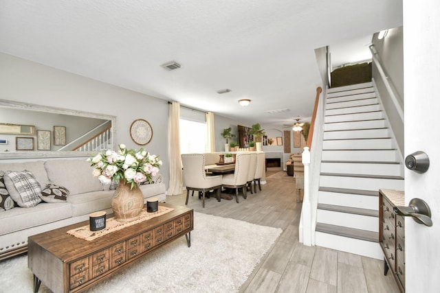 living room featuring light wood-type flooring and ceiling fan