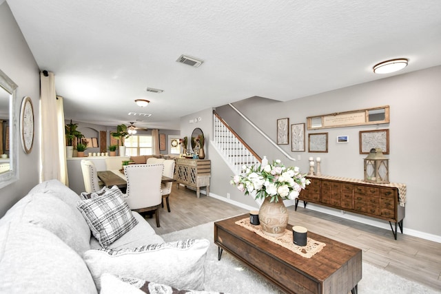 living room with a textured ceiling and light hardwood / wood-style flooring