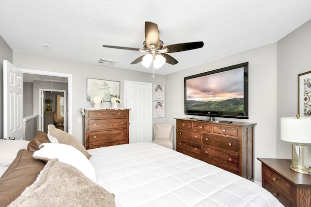 bedroom featuring ceiling fan and a textured ceiling