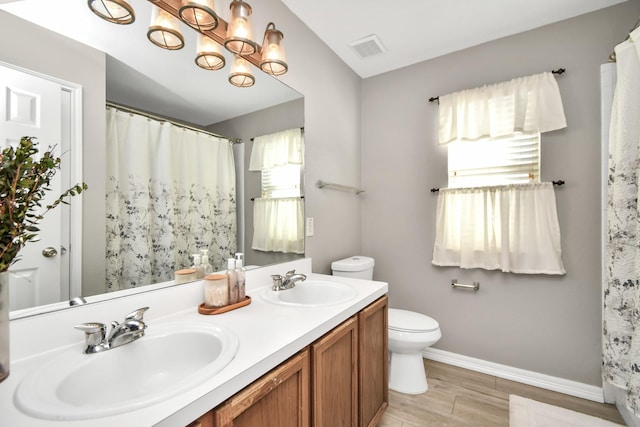 bathroom with vanity, toilet, and wood-type flooring