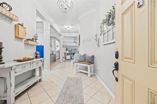 entryway featuring decorative columns, ornamental molding, light tile patterned flooring, baseboards, and ceiling fan with notable chandelier