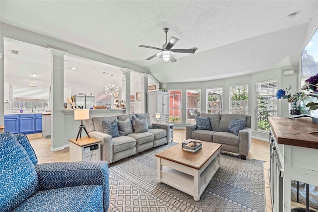 tiled living room featuring ceiling fan with notable chandelier, sink, vaulted ceiling, a textured ceiling, and decorative columns