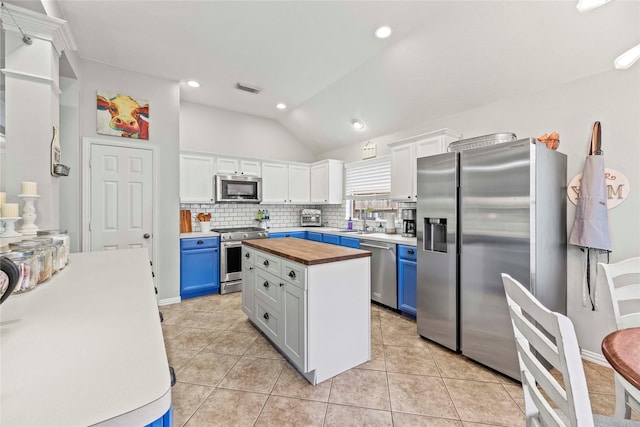 kitchen with white cabinets, wood counters, blue cabinets, and stainless steel appliances