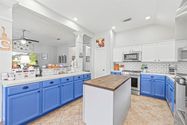 kitchen with ceiling fan, blue cabinetry, white cabinetry, kitchen peninsula, and stainless steel appliances