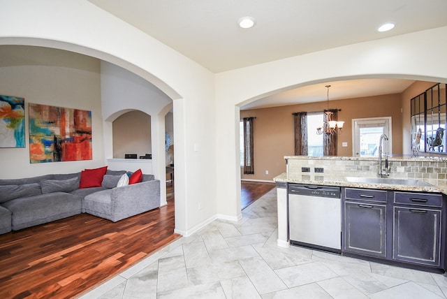 kitchen featuring decorative backsplash, sink, decorative light fixtures, a notable chandelier, and dishwasher