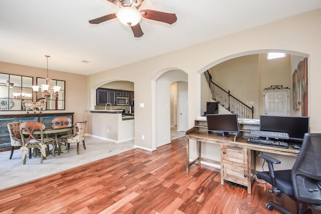 office area featuring hardwood / wood-style flooring and ceiling fan with notable chandelier