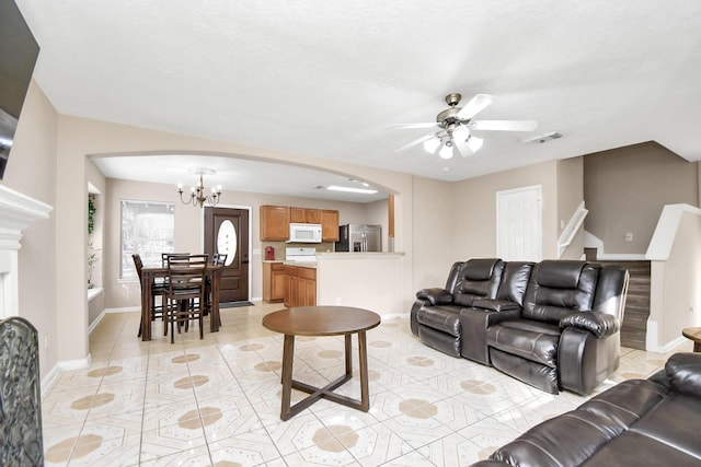 living room featuring ceiling fan with notable chandelier and light tile patterned flooring