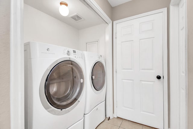 laundry room featuring light tile patterned floors and washing machine and dryer