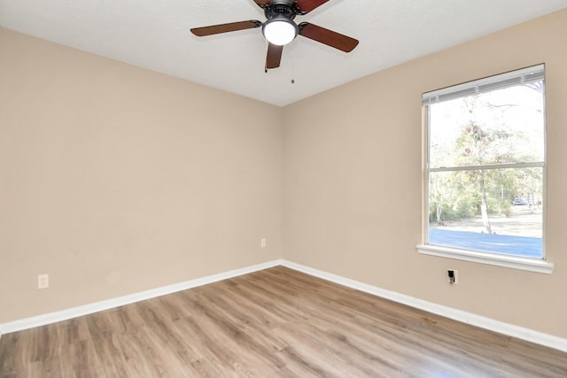 empty room featuring ceiling fan, a healthy amount of sunlight, and light hardwood / wood-style floors