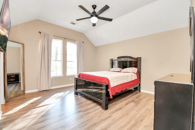 bedroom featuring light hardwood / wood-style flooring, vaulted ceiling, and ceiling fan