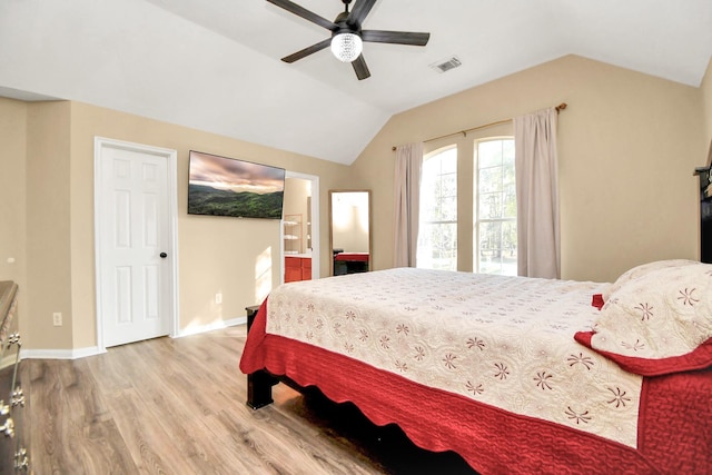 bedroom featuring connected bathroom, ceiling fan, wood-type flooring, and lofted ceiling