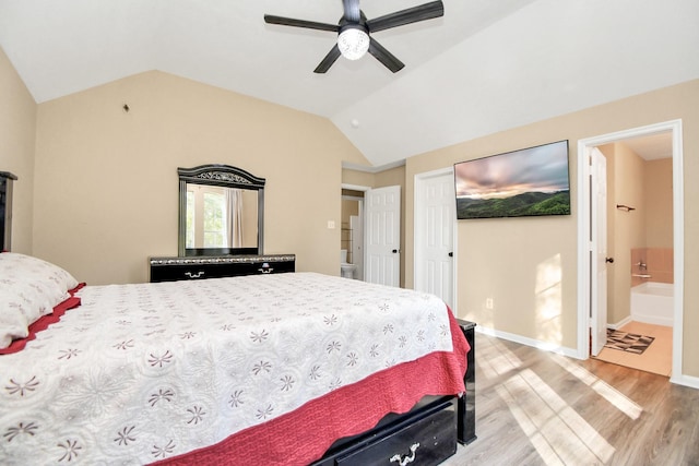 bedroom featuring connected bathroom, ceiling fan, light hardwood / wood-style flooring, and vaulted ceiling