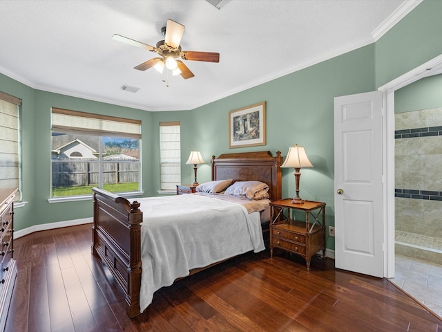 bedroom with ceiling fan, crown molding, ensuite bathroom, and dark wood-type flooring