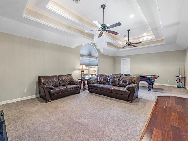 carpeted living room with ceiling fan, a raised ceiling, crown molding, and pool table