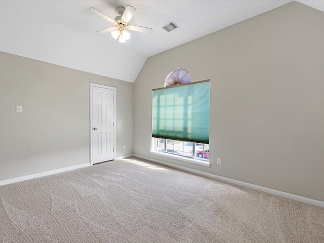 spare room featuring carpet flooring, vaulted ceiling, and ceiling fan