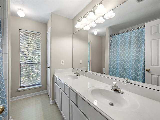 bathroom with vanity, toilet, and a textured ceiling