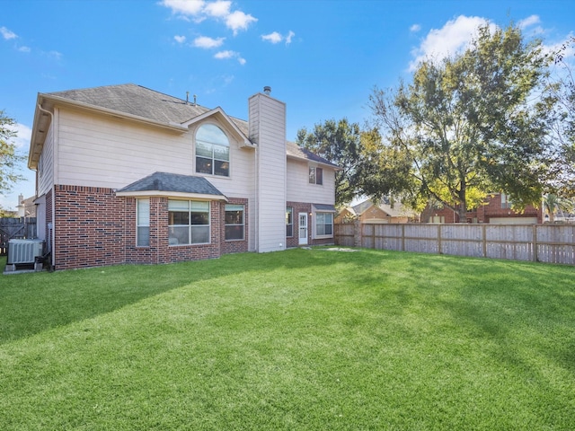 back of property with a lawn and central air condition unit