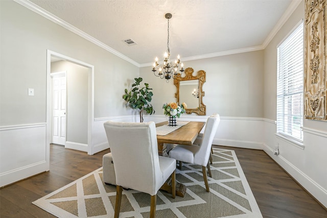 dining space with dark hardwood / wood-style flooring, crown molding, and a chandelier