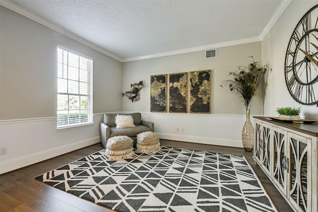 sitting room featuring a textured ceiling, dark hardwood / wood-style floors, and crown molding