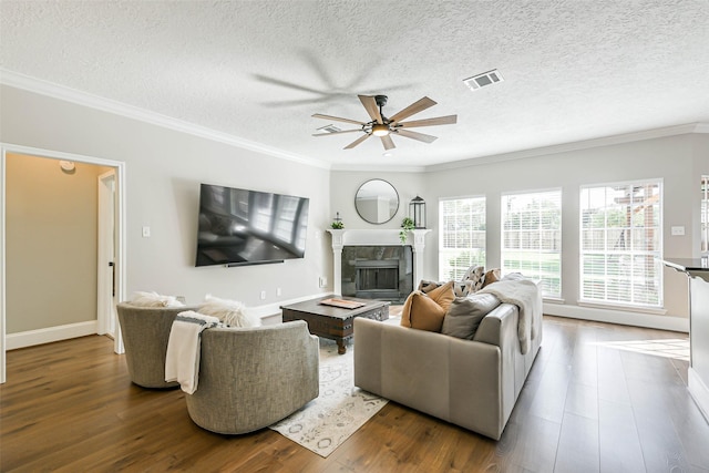 living room with crown molding, dark hardwood / wood-style flooring, ceiling fan, and a textured ceiling