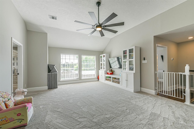 playroom with a textured ceiling, ceiling fan, light colored carpet, and vaulted ceiling