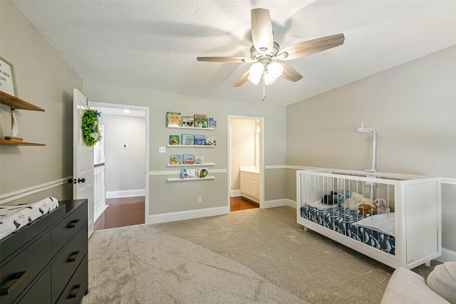 bedroom with carpet flooring, ceiling fan, a textured ceiling, and connected bathroom