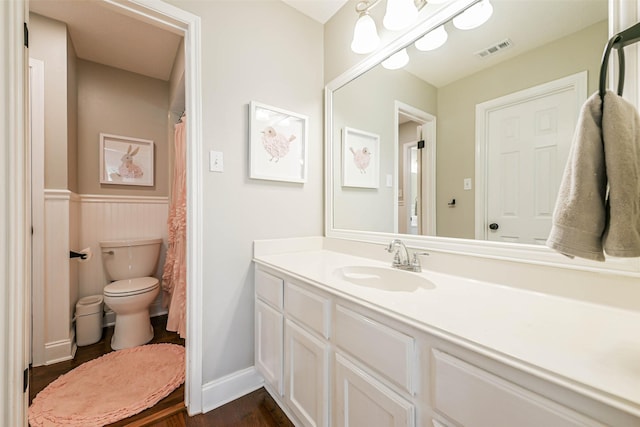 bathroom with hardwood / wood-style flooring, vanity, and toilet