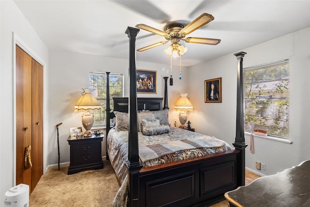 bedroom featuring light carpet, a closet, multiple windows, and ceiling fan