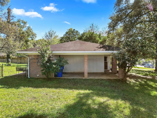 rear view of property featuring a patio area and a yard