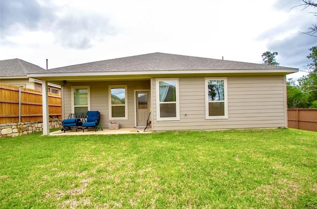 rear view of property with fence, a lawn, and a patio