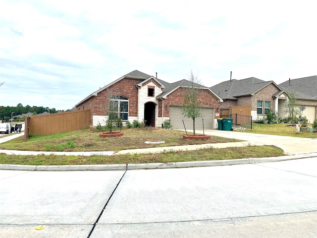 traditional-style house featuring a garage, fence, concrete driveway, and brick siding