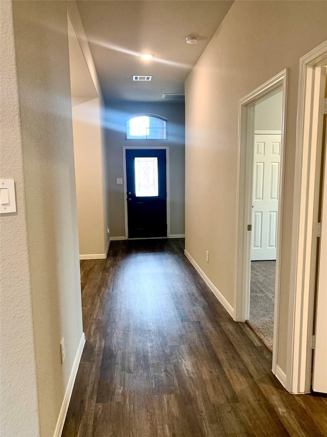 foyer with dark wood-style flooring, visible vents, and baseboards