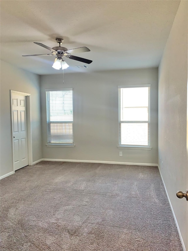 unfurnished room with carpet flooring, plenty of natural light, and baseboards