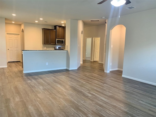 kitchen with arched walkways, appliances with stainless steel finishes, and visible vents