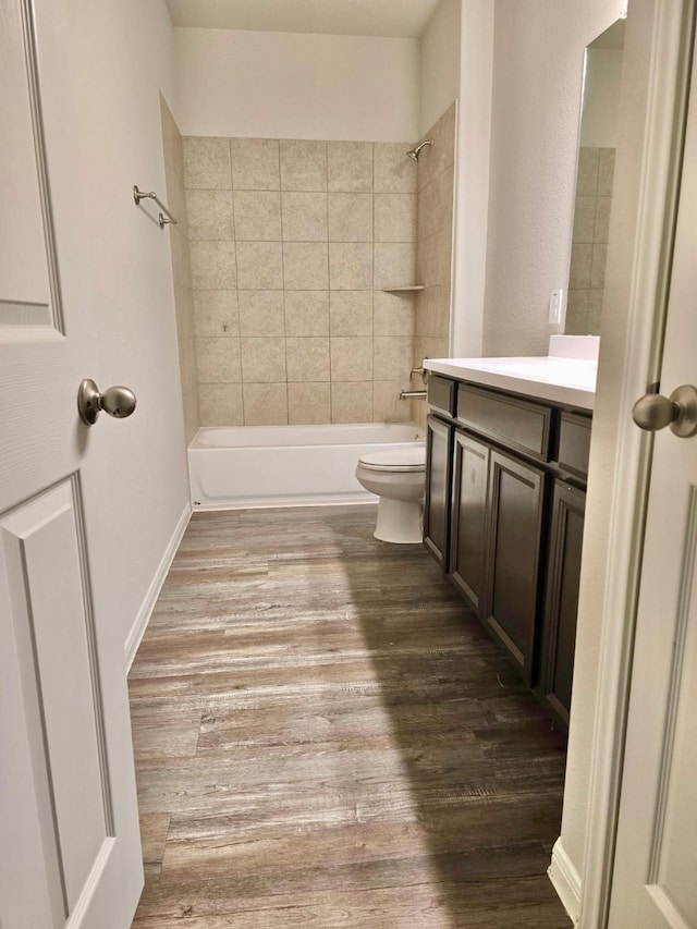 bathroom with shower / washtub combination, vanity, toilet, and wood finished floors